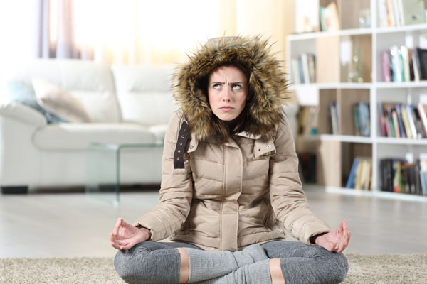 image of a homeowner feeling chilly due to undersized home heating furnace system