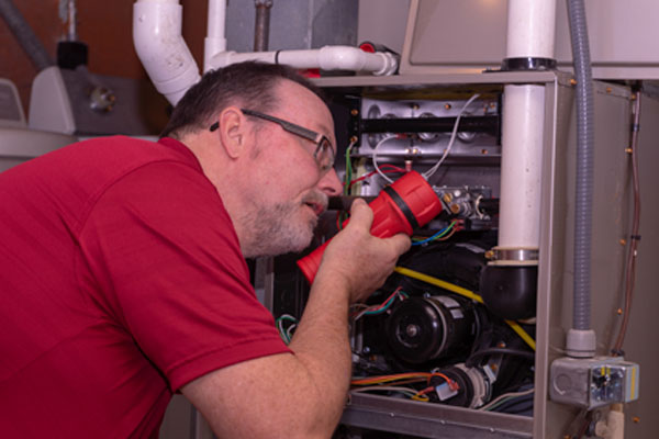 HVAC contactor examining a residential oil-fired furnace