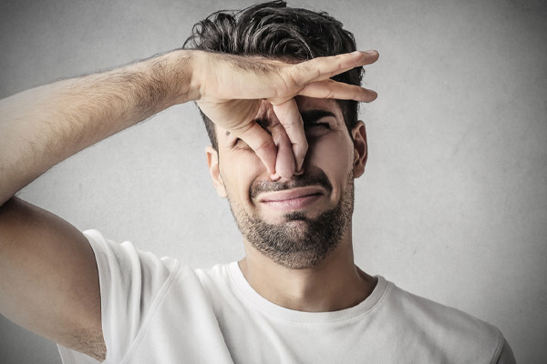 image of a homeowner plugging nose due to furnace heating oil smells