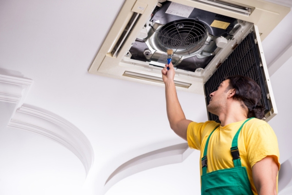 professional HVAC technician examining home centralized AC system