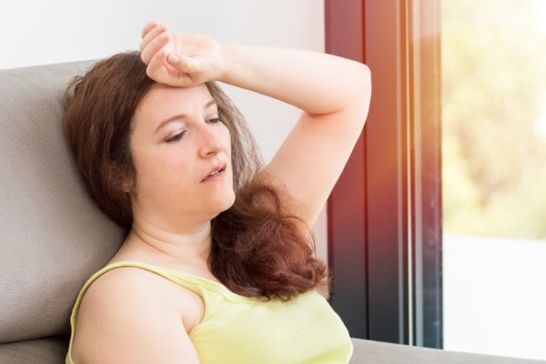 woman experiencing intense summer heat due to AC breakdown