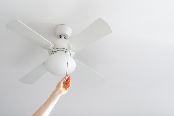 homeowner setting ceiling fan in the right direction for effective cooling