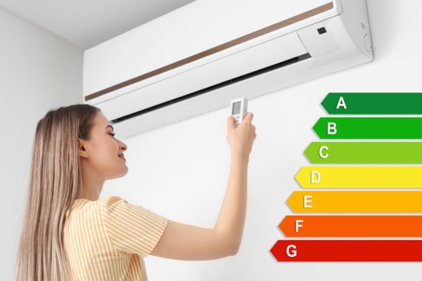 woman turning on home air conditioner with energy efficiency chart depicting SEER rating