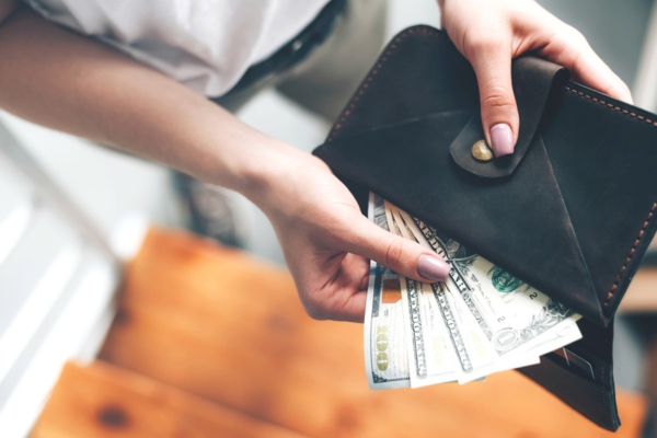 man bringing dollars out of his wallet depicting double-wall fuel oil tank as a more expensive option