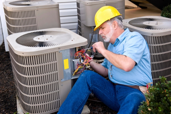 HVAC Contractor addressing air conditioner outdoor unit issues