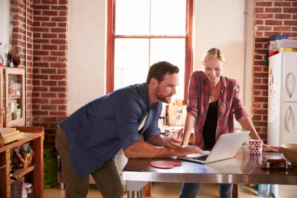 couple talking and researching in the kitchen depicting boiler brand names