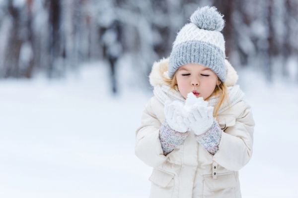 image of a kid playing with heavy snow during winter depicting home heating and oil fired boiler