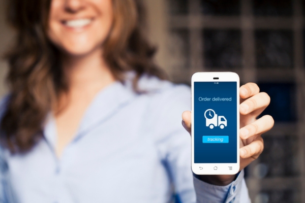 cropped view of a woman showing phone screen saying order delivered depicting automatic heating oil delivery