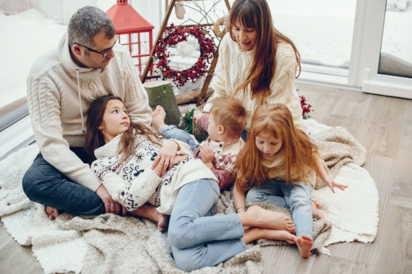 family lounging in the living room floor depicting properly working HVAC system