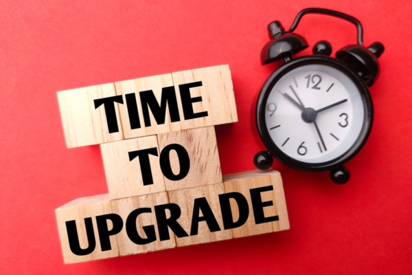 Time to upgrade on wooden letter cubes beside an alarm clock depicting air conditioner replacement