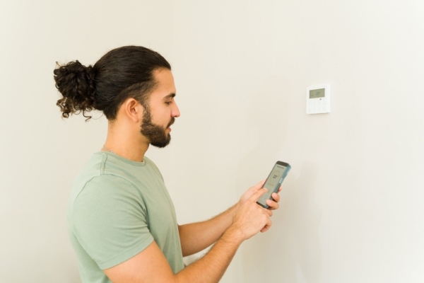 man synching home temperature with his smart phone