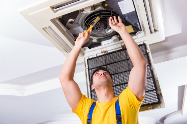 HVAC technician performing air conditioner maintenance