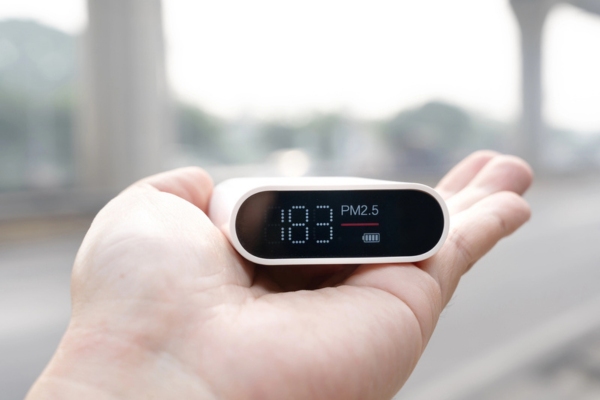 hand holding air pollution monitor to measure indoor air quality