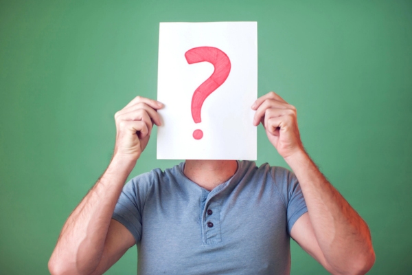man holding a card with a question mark in front of his face depicting FAQs about air conditioner problems