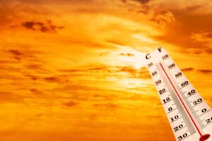 summer sun and thermometer depicting warm temperature