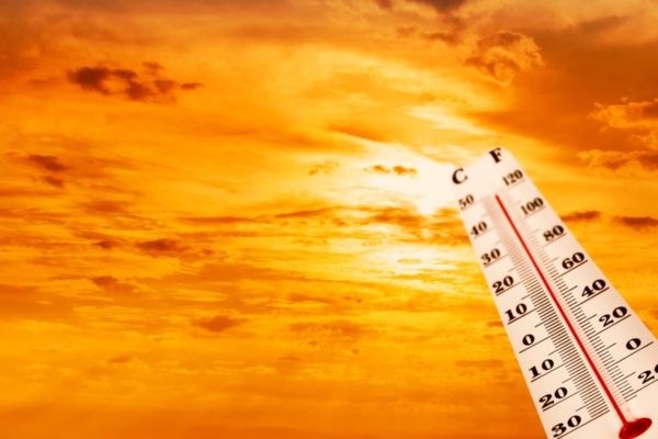 summer sun and thermometer depicting warm temperature