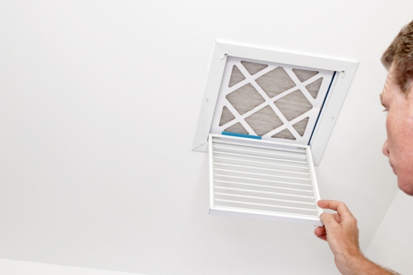 homeowner looking at the HVAC air filter in the ceiling