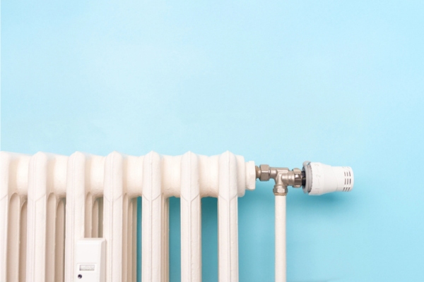 close up view of a home oil-heat radiator and thermostat control