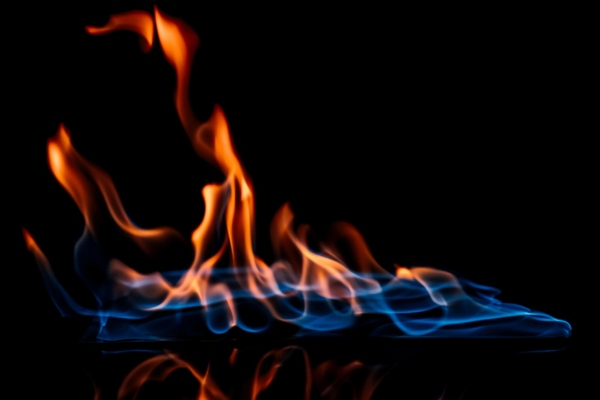 Close up view of burning orange and blue flame depicting furnace pilot light