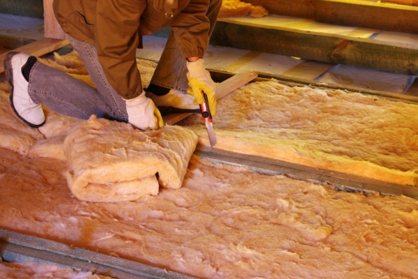 worker cutting and installing home insulation