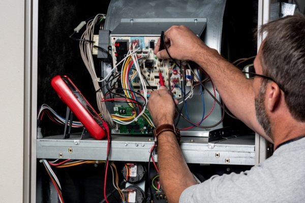 HVAC technician performing furnace maintenance