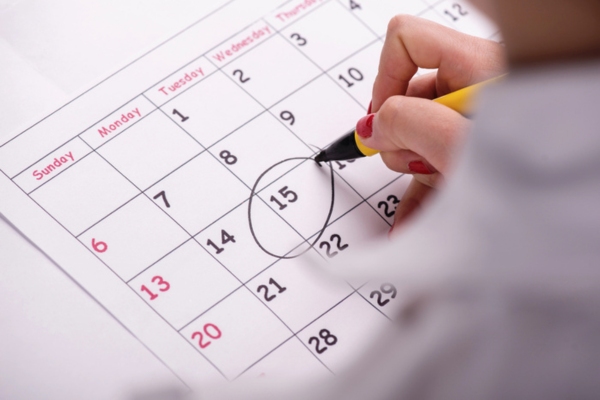 homeowner encircling a date on a calendar for an HVAC repair schedule