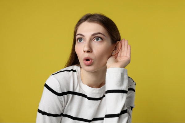 woman cupping ear listening to strange sounds from HVAC system