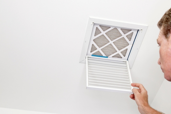 homeowner opening an air vent depicting Leaky HVAC Ductwork