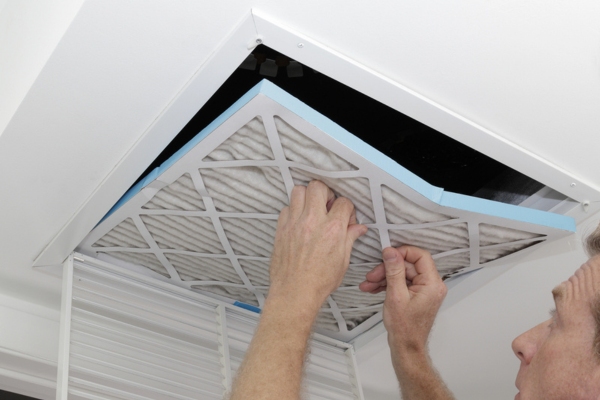 homeowner inspecting HVAC air filter