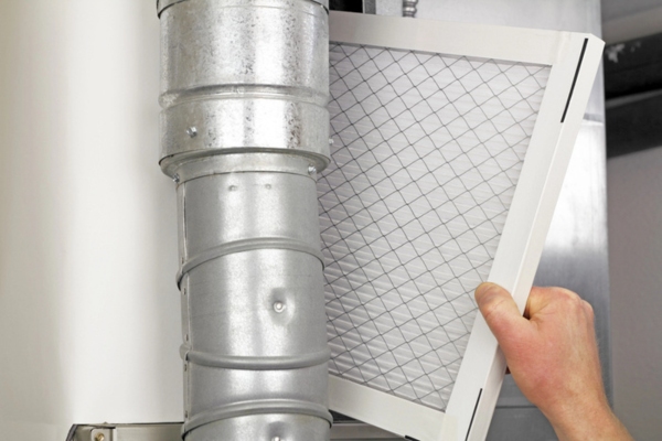 image of a homeowner installing new HVAC air filter