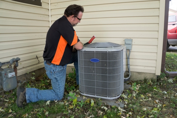 professional HVAC technician checking air conditioner for mechanical issues