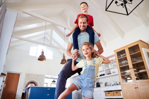 father and kids playing at home depicting improved comfort from new AC