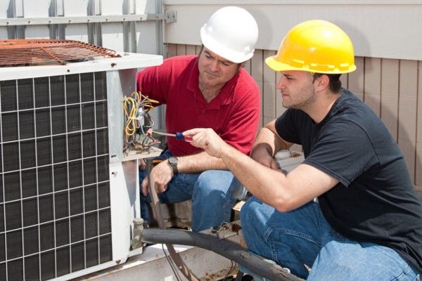 HVAC technicians tending to an outdoor unit