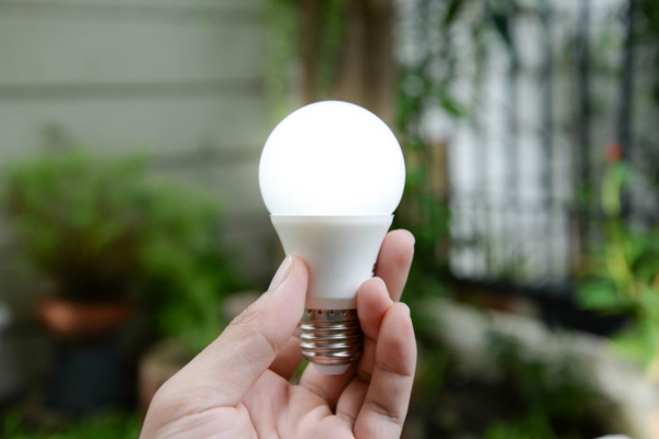 homeowner holding LED light depicting flickering light when AC turns on