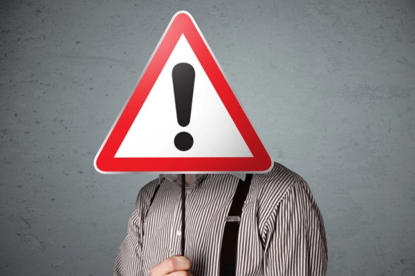 homeowner holding exclamation sign depicting Warning Signs That Point to a Larger Problem