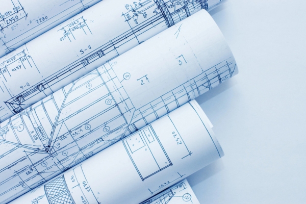 Rolls of building blueprints depicting Transforming Building Design