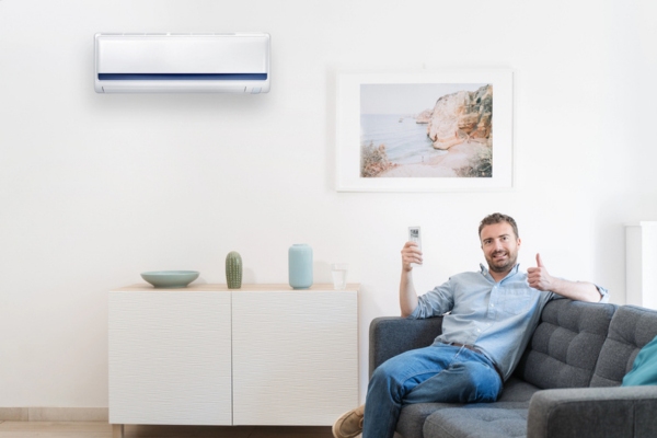 man turning on ductless AC while doing a thumbs up depicting Emergency Air Conditioner Preparedness