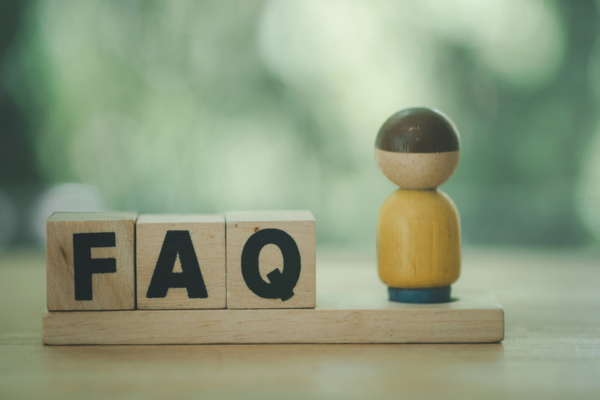 FAQ spelled using wooden letter cubes beside a miniature man figure depicting End Of Summer AC Tips Questions