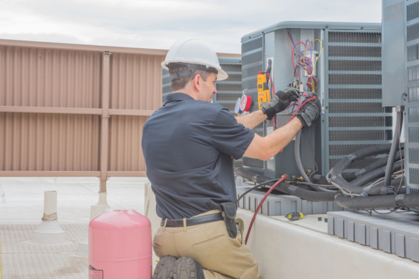 HVAC tech checking air conditioner condenser