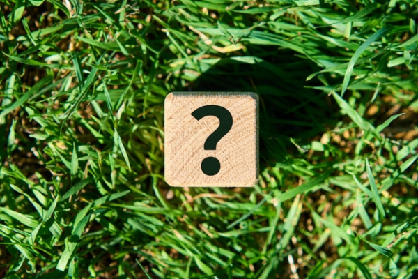 question mark on a wooden cube on top of grass depicting FAQs About Local Heating Oil Suppliers